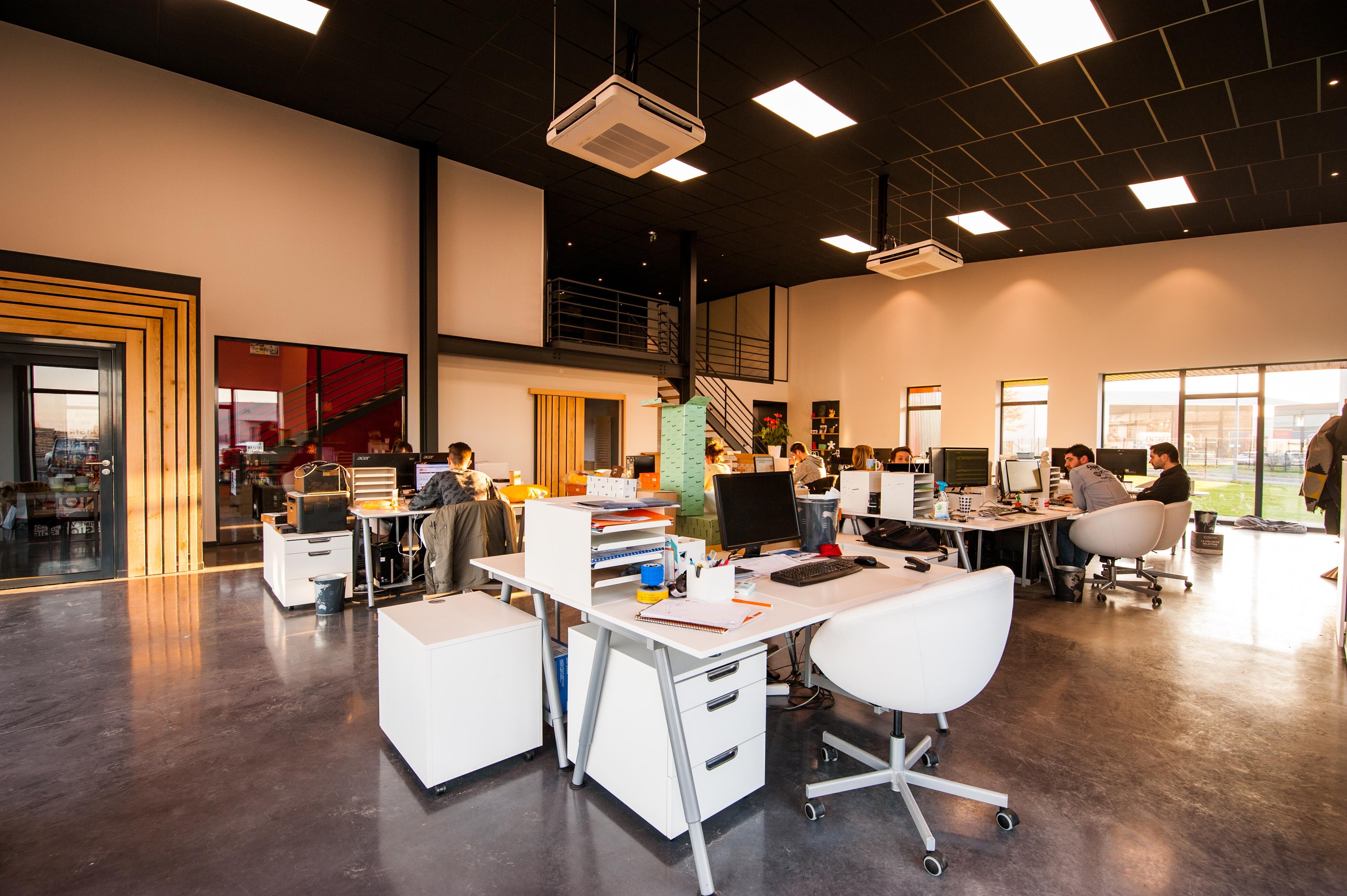 Large office building with multiple white desks and computers